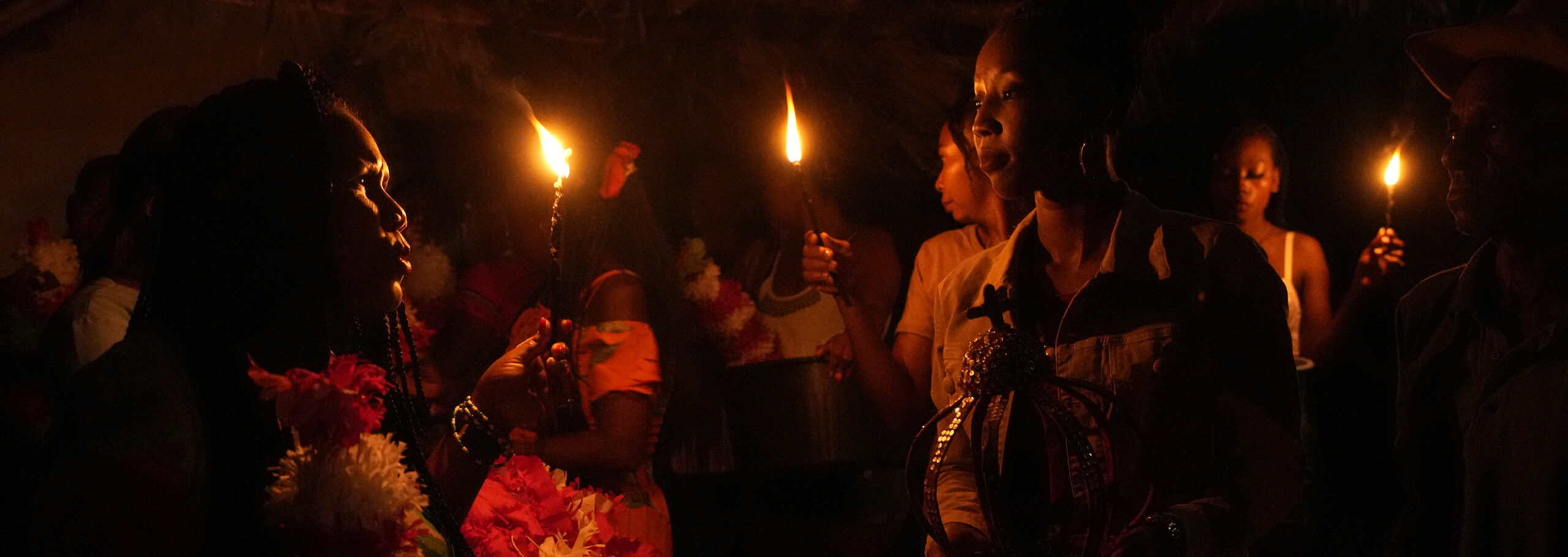 A member of the Kalunga quilombo, the descendants of runaway slaves, prepares to attend the candle procession during the culmination of the week-long pilgrimage and celebration for the patron saint "Nossa Senhora da Abadia" or Our Lady of Abadia, in the rural area of Cavalcante in Goias state, Brazil, Saturday, Aug. 13, 2022. Devotees celebrate Our Lady of Abadia at this time of the year with weddings, baptisms and by crowning distinguished community members, as they maintain cultural practices originating from Africa that mix with Catholic traditions. (AP Photo/Eraldo Peres)
